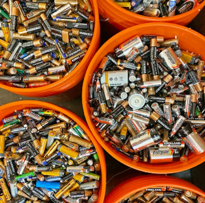 Brukte batterier sortert i oransje bøtter